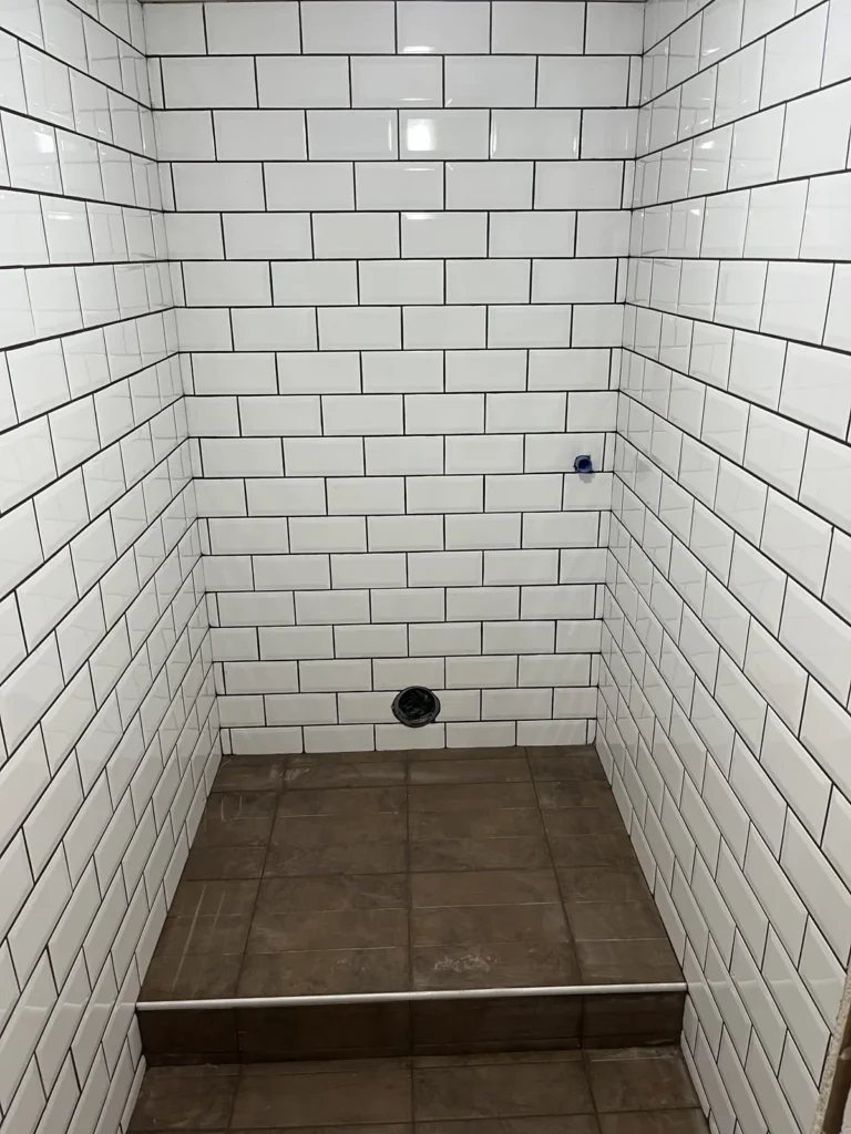 Fehér metrócsempe falburkolat padlóösszefolyóval